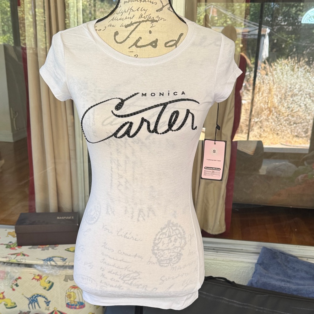 Monica Carter White Tee with Black rhinestone Script Design. Fits like a size 2